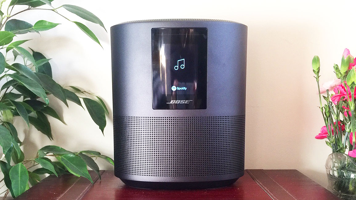 En smart-høyttaler av typen Bose Home Speaker 500 på et bord i et oppholdsrom.