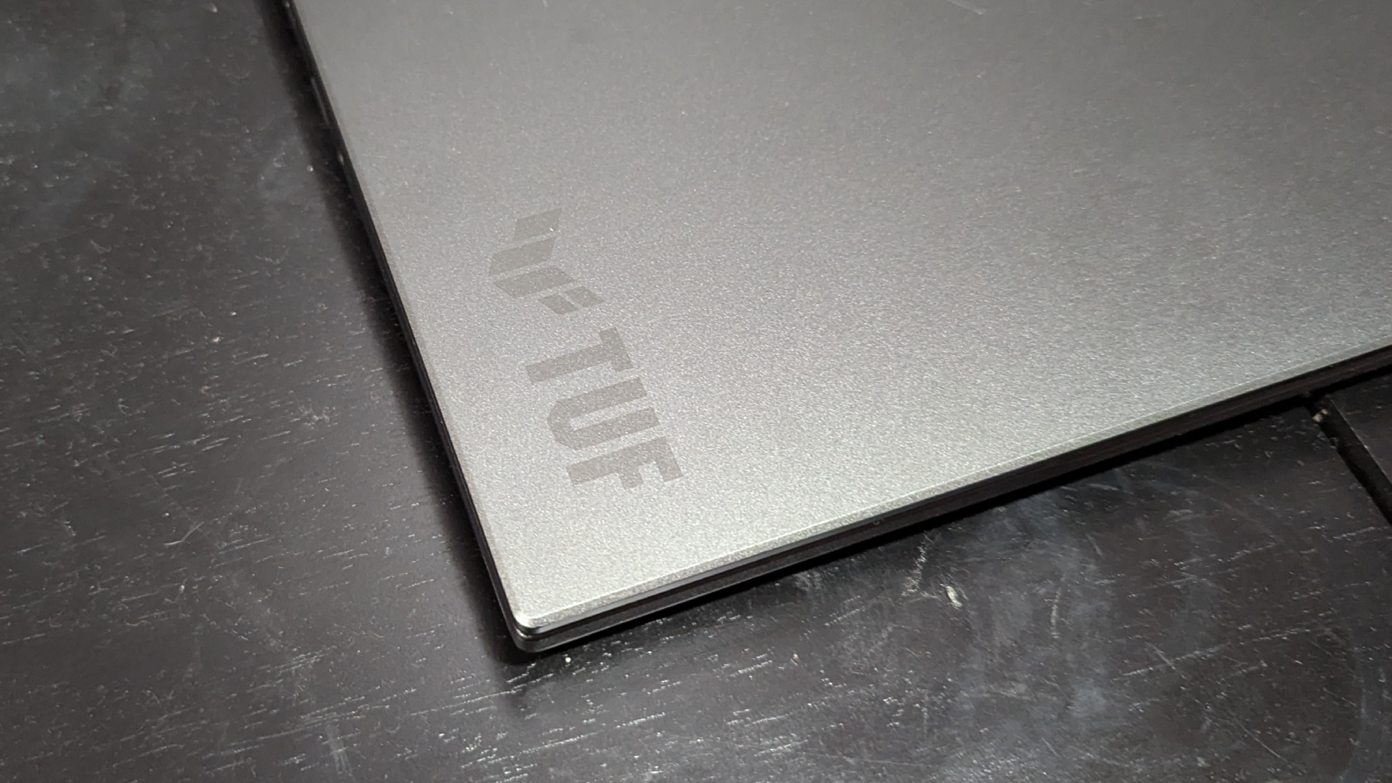 A close up of a laptop logo on the corner of a laptop lid.