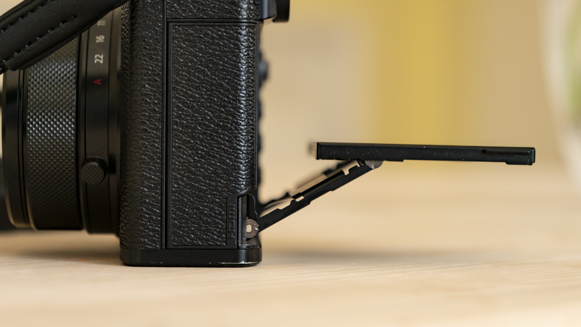All-black Fujifilm GFX100RF rangefinder-style camera on a wooden table