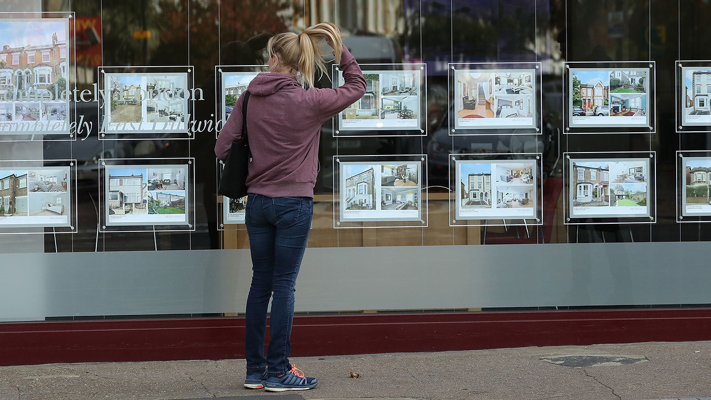 Woman looking in an estate agent's window