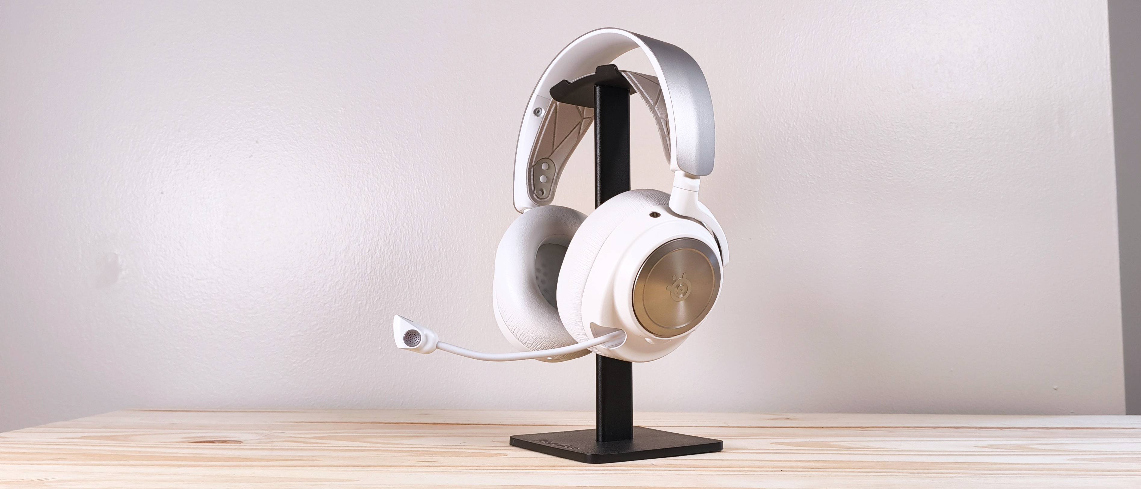 The SteelSeries Arctis Nova Pro on a headphone stand on a wood table