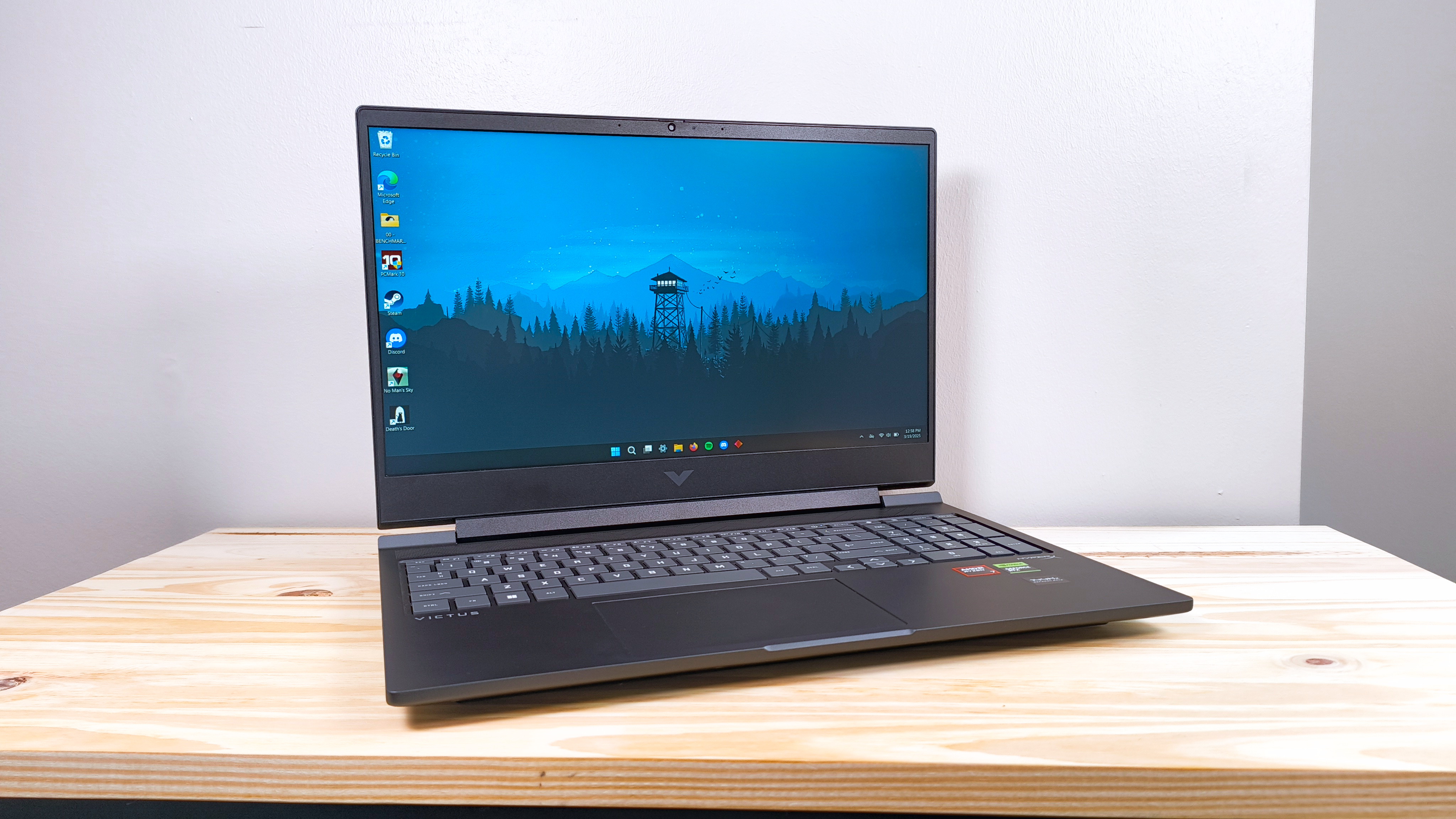The HP Victus 16 (S100) with lid open on a wood table