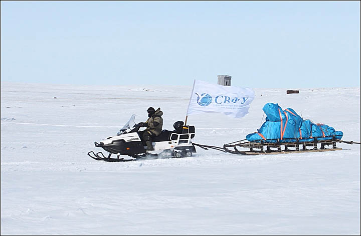 A sled team carries a mammoth carcass