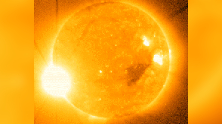 Image of the sun with a bright yellowy white "flash" of light — the X9 flare — in the lower left corner.