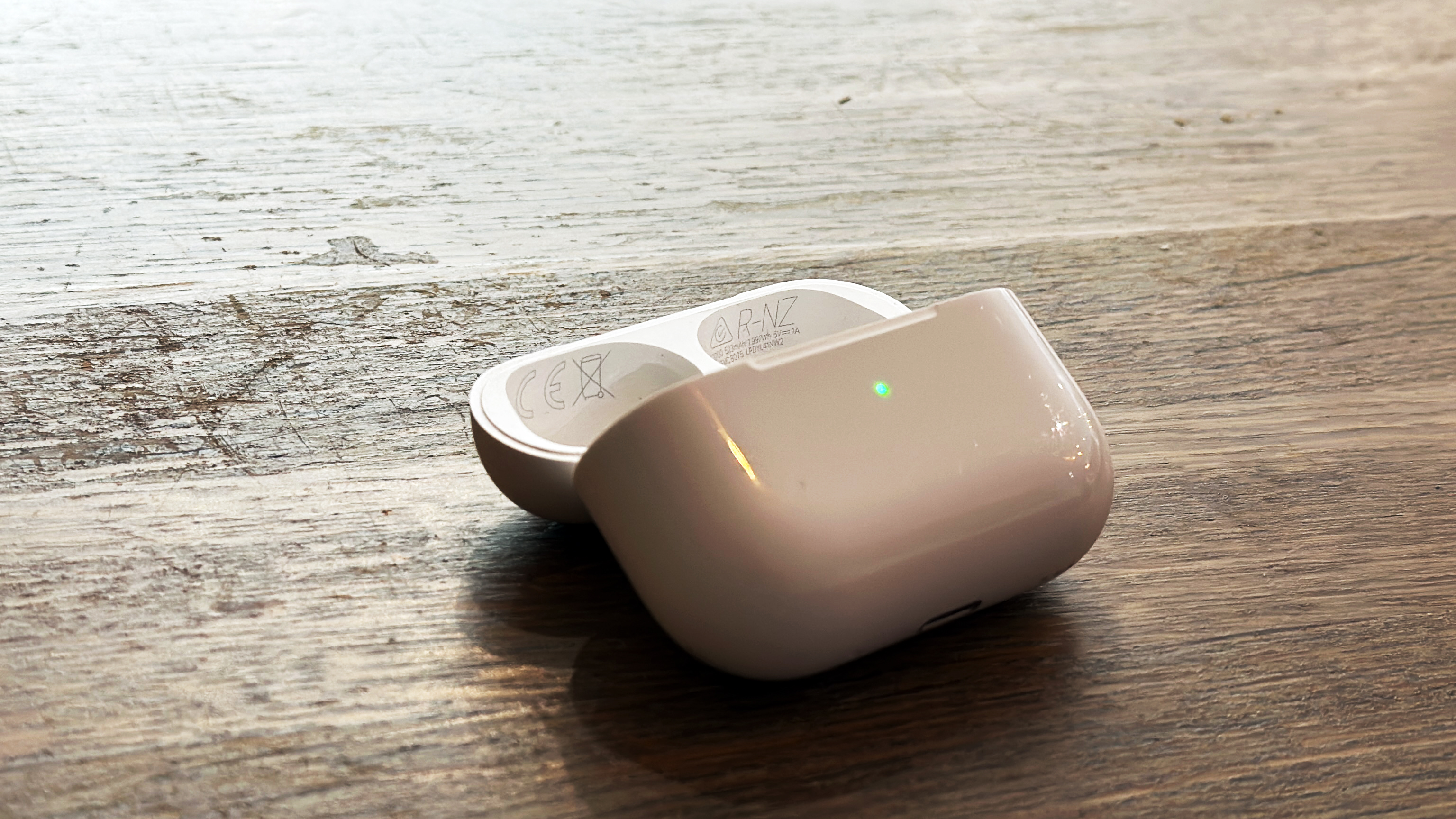AirPods Pro 2 latauskotelo avattuna puiselle pinnalle